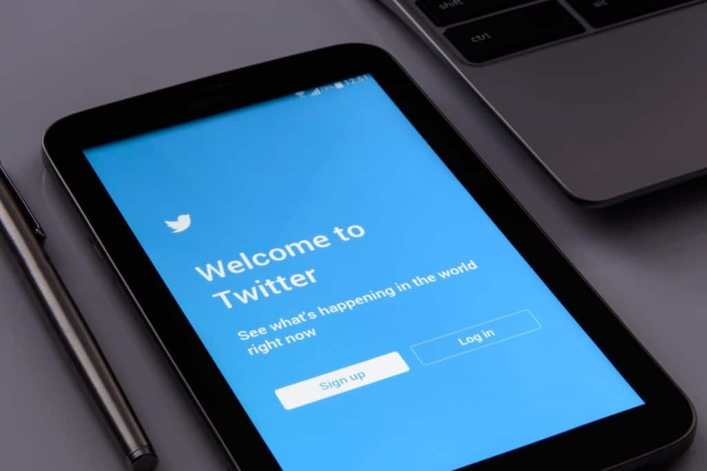 a smartphone on a desk displaying the login screen for Twitter