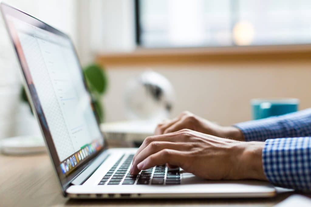 person typing on laptop representing AOTA requirements for business websites