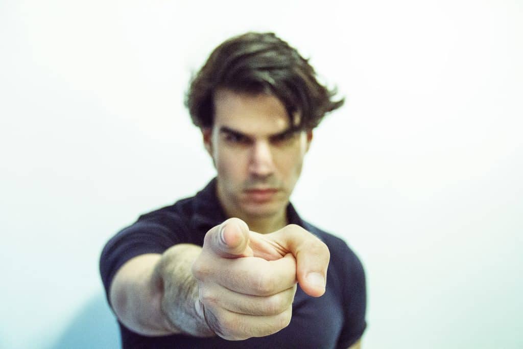 a man looking angry and pointing at camera, representing an accusatory situation