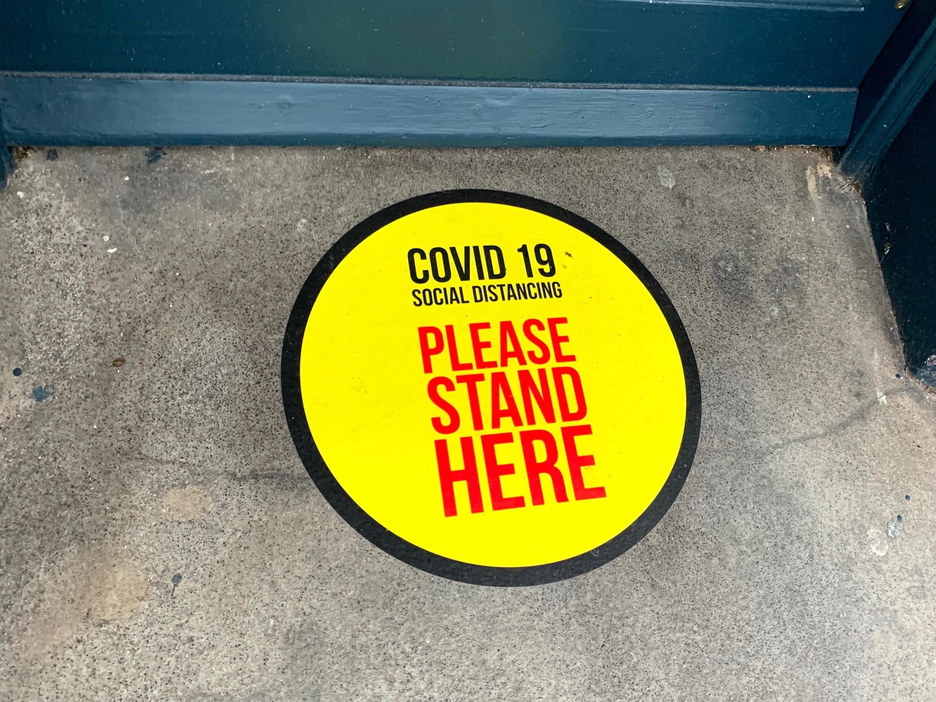 A covid sticker on the ground at a business representing reasonable efforts to maintain safety relating to Bill 218