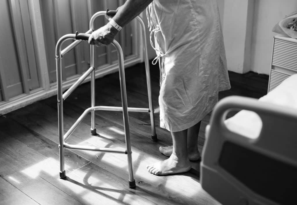 a man in a hospital gown using a walker