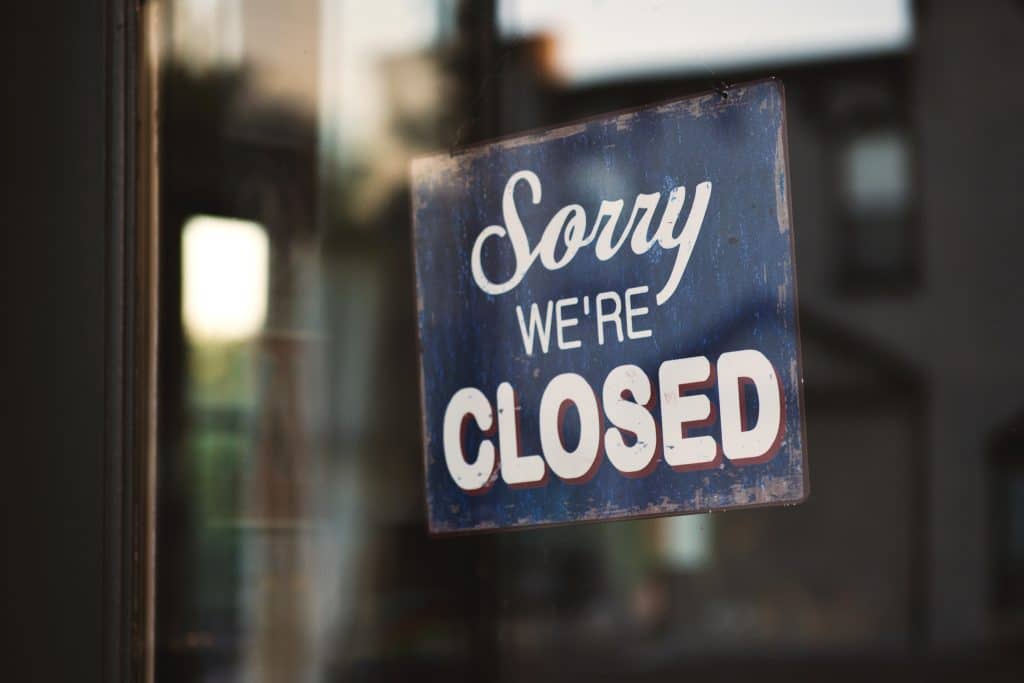 a sign behind a glass door that reads 'sorry we're closed'