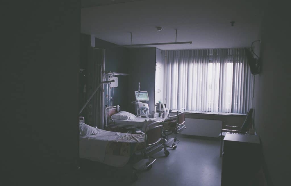 a hospital room, representing an illness requiring an insurance claim for an employee