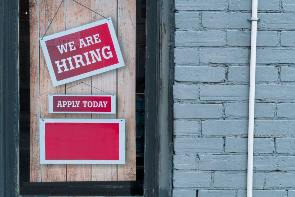 A sign indicating available employment in a window