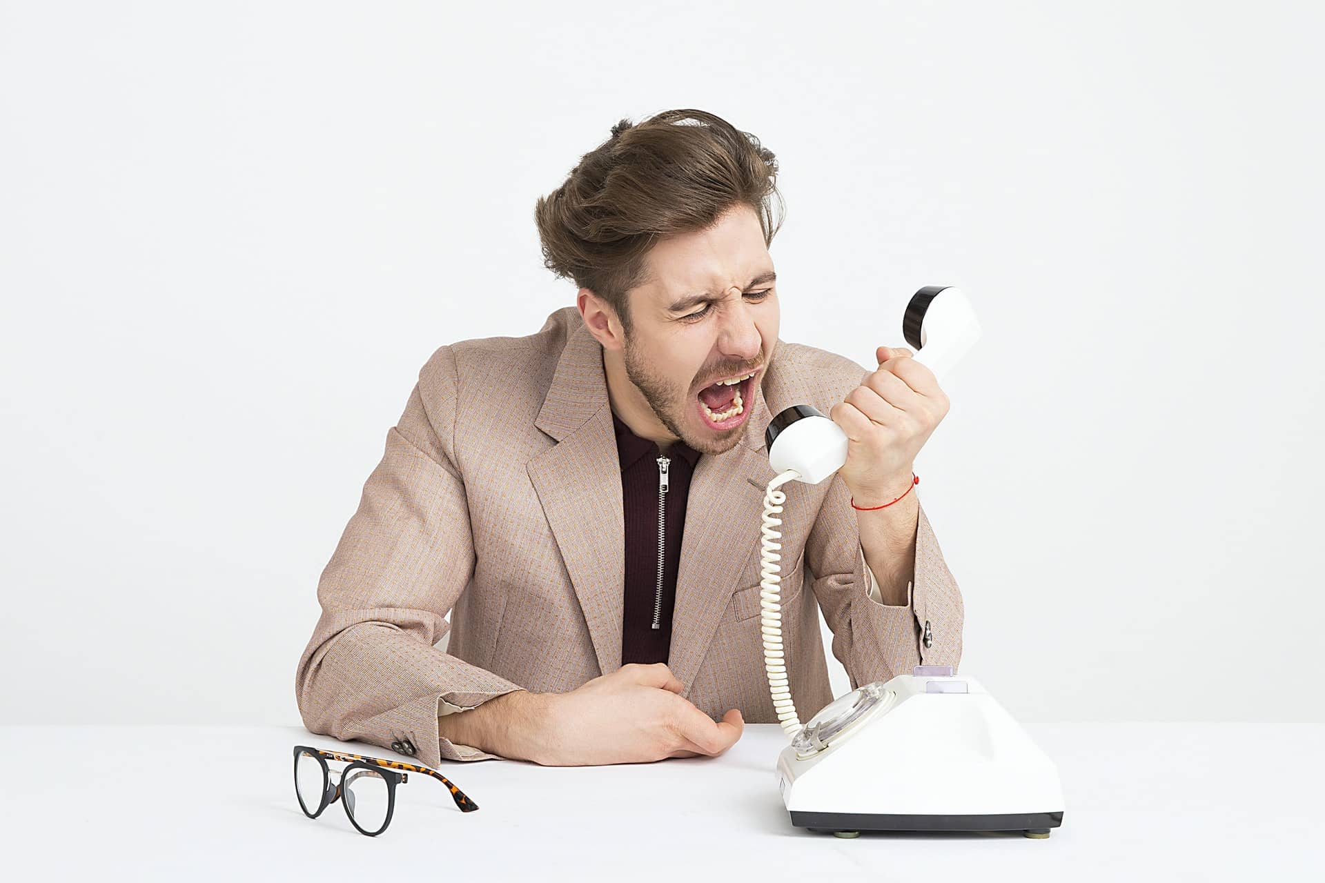 A man yelling into a phone representing workplace harassment and violence