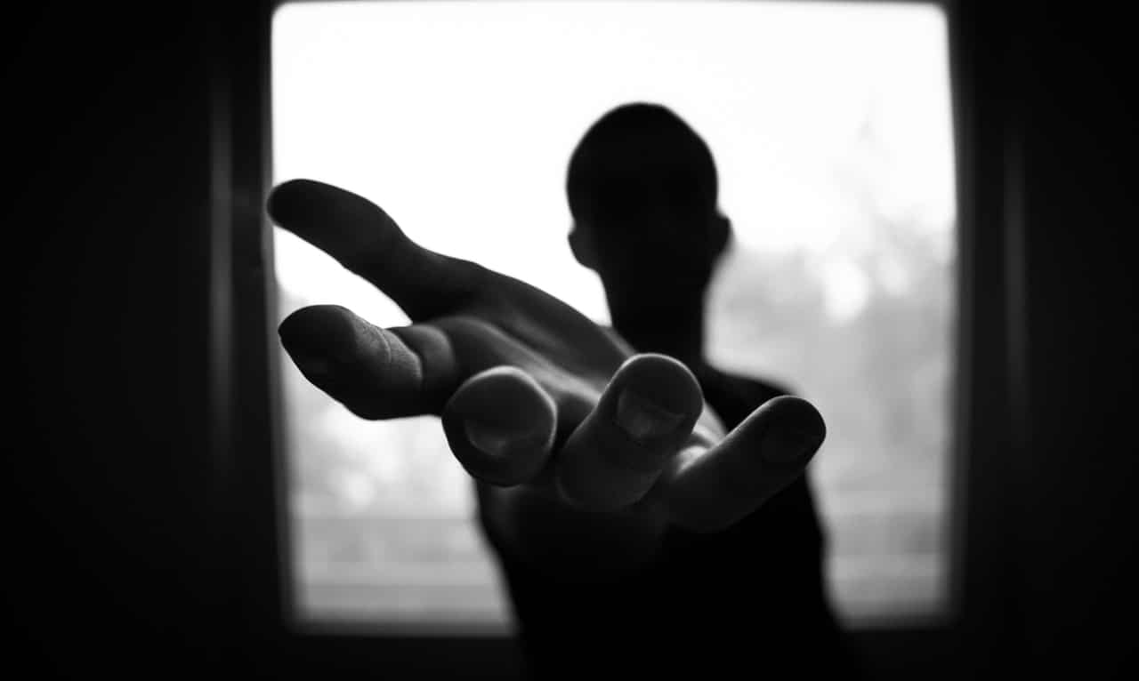 A man reaching out his hand, representing offering help to an employee suffering from mental distress