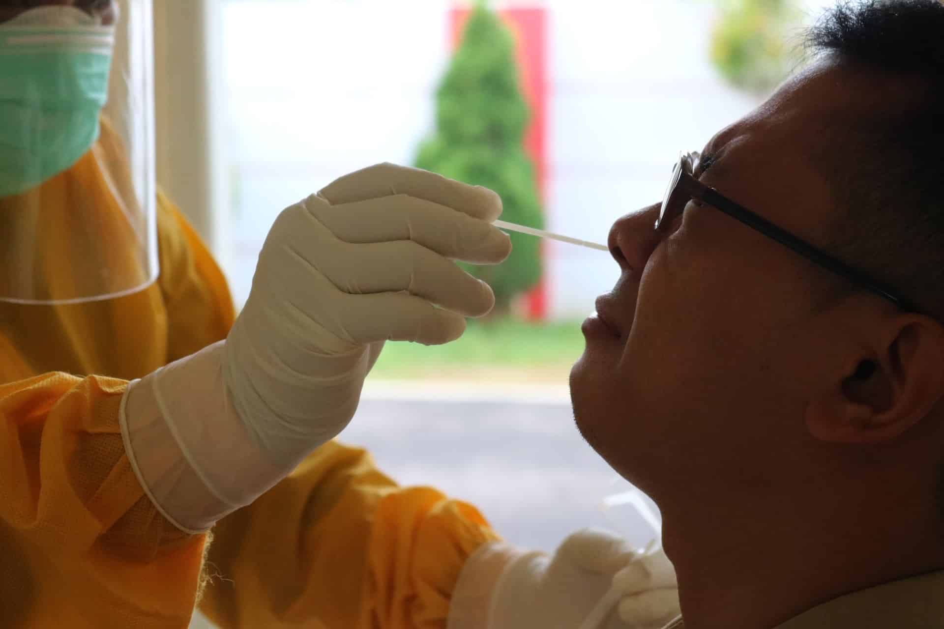 A man getting a nasal Covid test representing an employer's right to make testing mandatory