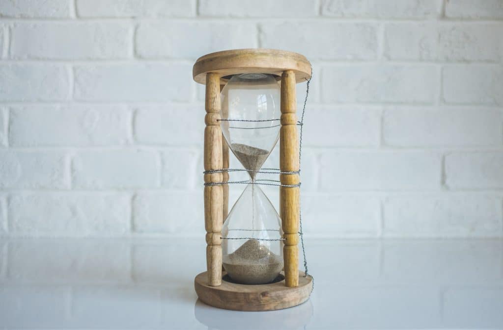 an hourglass timer representing an employer's obligation to provide an ROE within a certain timeframe