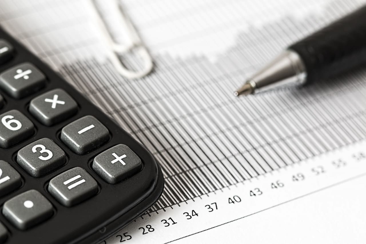 A calculator and pen on a spreadsheet indicating the calculation of an employer's CEWS entitlement under the new rules