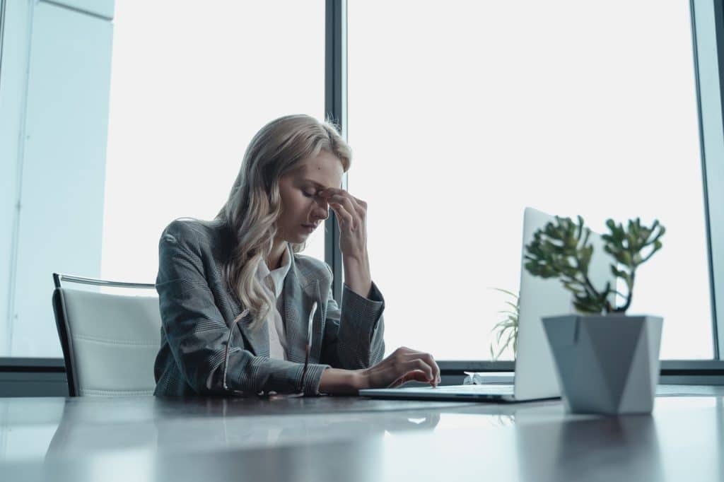 A woman under stress at work representing the ability to sue an employer for constructive dismissal for chronic mental stress