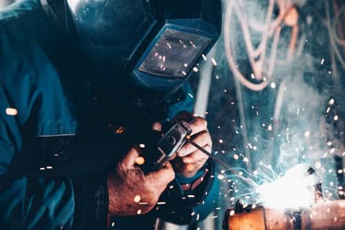 A person using welding equipment representing a welder who lost their job after their employer sold the business