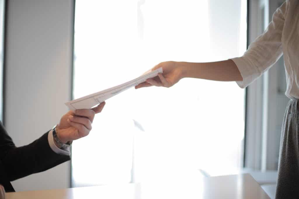 A person handing an employee a termination letter, representing punitive damages against employers based on conduct during termination