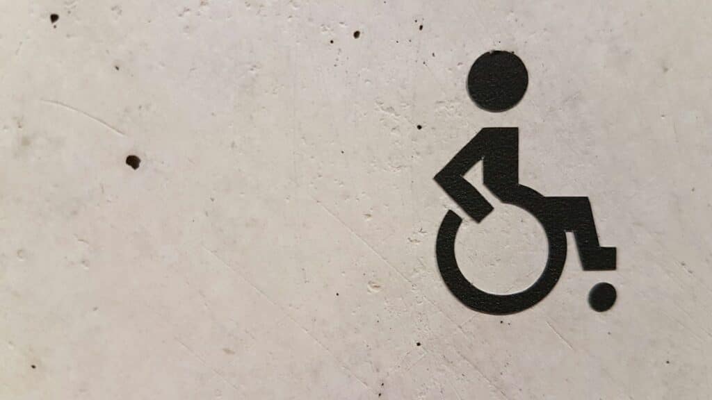 A wheelchair sign painted on a wall represents discrimination.