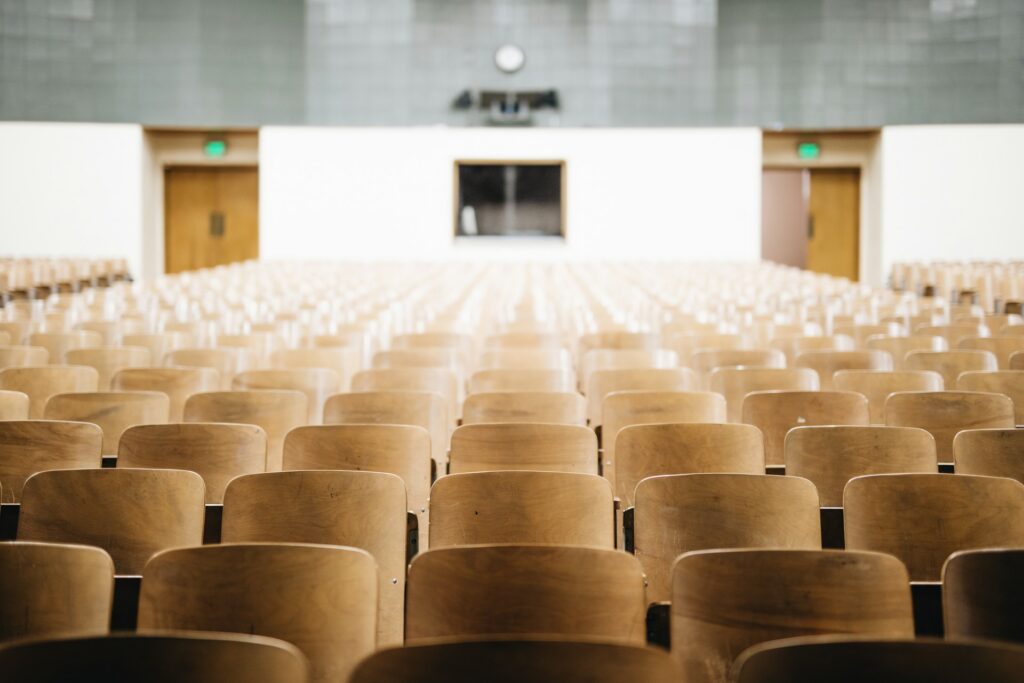 Rows of empty wooden seats in a college auditorium, representing the Ontario college strike.