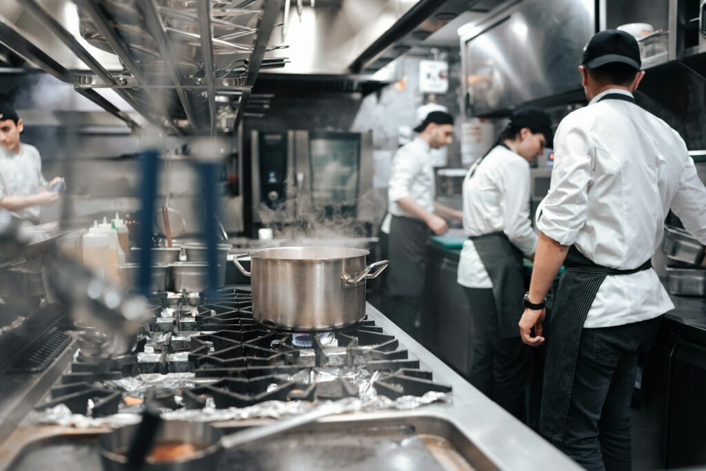 Cooks working in a busy restaurant kitchen, representing the ESA reprisal complaint decision in Sunset Grill, and Ontario Employment Standards litigation.